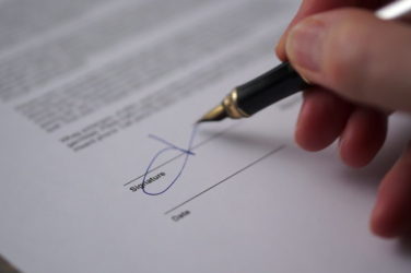Pen signing a document